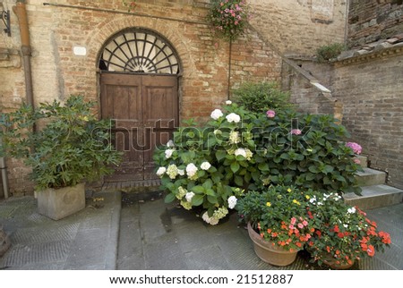 Buonconvento (Siena, Tuscany, Italy) - Ancient typical house with wooden house, stairs and potted plants and flowers