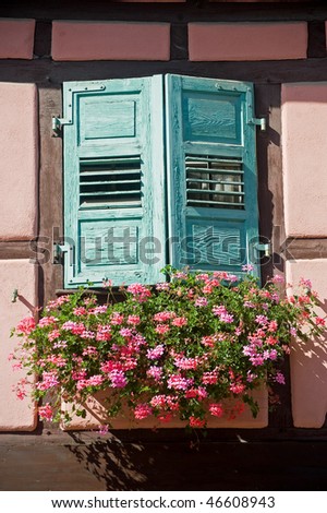 Boersch (Bas-Rhin, Alsace, France) - Exterior of pink half-timbered house: window with green shutters and red flowers
