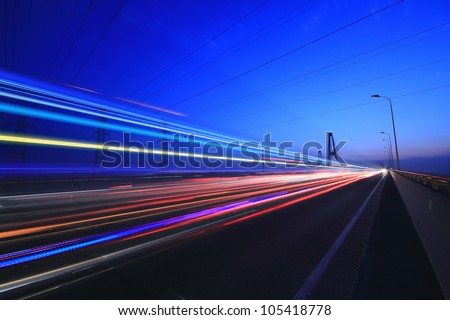 Car lights on a highway and transmission tower at night, long exposure photo of traffic