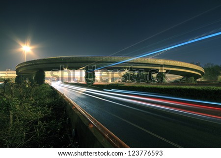Large urban ring highway viaduct long exposure photo light trails night scene