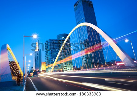 Modern city highway arc bridge night landscape of car light trails