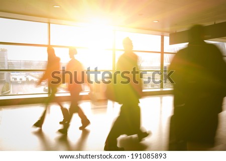 Modern airport passenger aisle interior glass wall of windows in hurry people