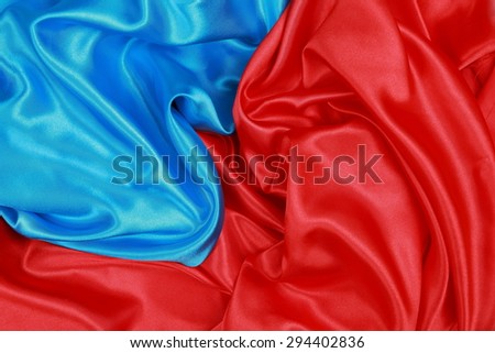Blue and red Silk cloth of abstract backgrounds or wavy folds or satiny silk texture satin velvet material or elegant wallpaper design curve.