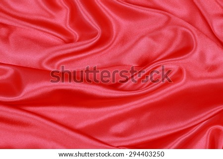 Red Silk cloth of abstract background or wavy folds or satiny silk texture satin velvet material or elegant wallpaper design curve.