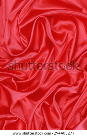 Red Silk cloth of abstract background or wavy folds or satiny silk texture satin velvet material or elegant wallpaper design curve.