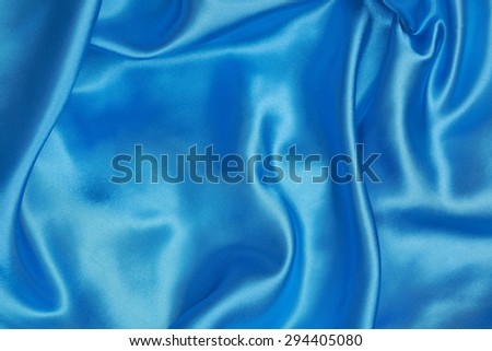 Blue Silk cloth of abstract background or wavy folds or satiny silk texture satin velvet material or elegant wallpaper design curve.