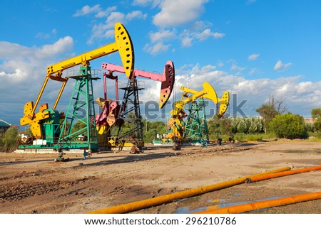Under sunny golden yellow and pink Oil pump oil rig energy industrial machine for petroleum crude of countryside dirt road