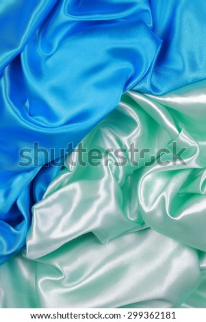 Blue and light green silk texture satin velvet material or elegant wallpaper design curve folds wavy background