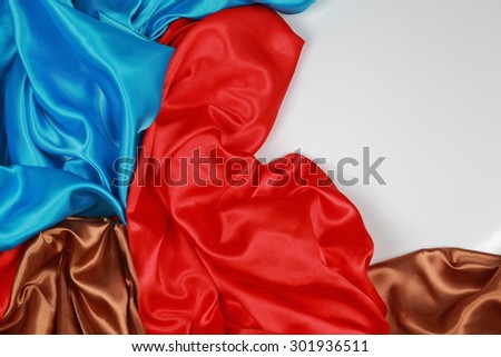 Blue and brown and red silk texture satin velvet material or elegant wallpaper design curve folds wavy background isolated on white background