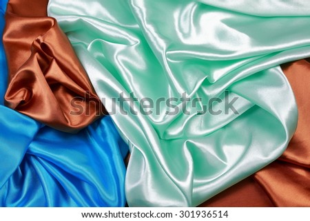 Blue and brown and light green silk texture satin velvet material or elegant wallpaper design curve folds wavy background
