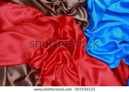 Blue and brown and red silk texture satin velvet material or elegant wallpaper design curve folds wavy background