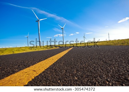 Environmentally friendly power generation wind power turbines on the side of dual carriageway road at panoramic