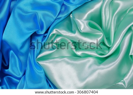 Blue and light green silk texture satin velvet material or elegant wallpaper design curve folds wavy background