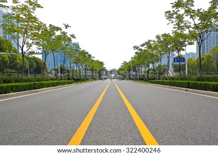 Empty straight line road surface with modern city buildings background