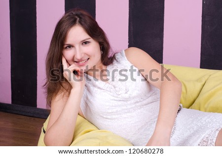smiling beautiful woman lying on a yellow couch