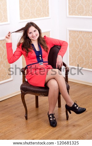 pretty brunette woman in red dress sit on chair