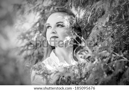 Portrait of a young lady on nature  in black and white toning