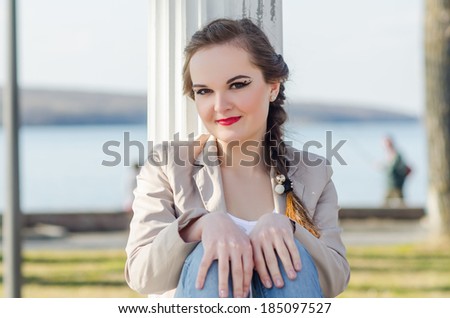 beautiful girl standing near column on nature