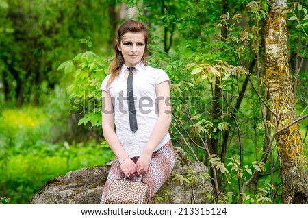 portrait of a pretty brunette  woman in wild cat make-up in the park