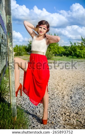 beautiful female model standing near the old wall graffiti
