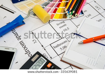 Paintbrushes and colorful paint samples on house plan  with pencil, notebook, tea as background