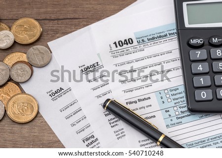 1040 tax form, us coins, pen and calculator