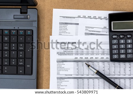 Document - Personal Budget with a laptop, a calculator and a river on the table.