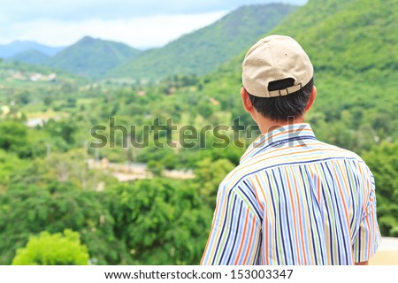 Backside senior man looking view green mountain