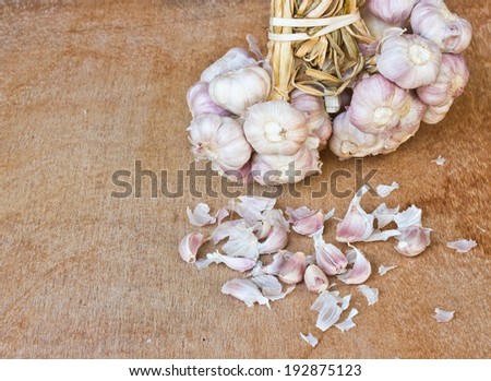 garlic on brown textured wood. It is a herb.