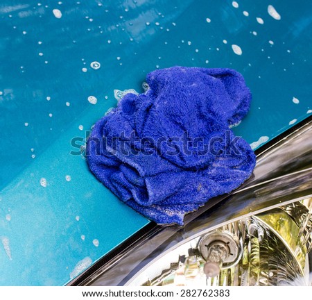 Blue car wash cloths on the hood of a blue car.