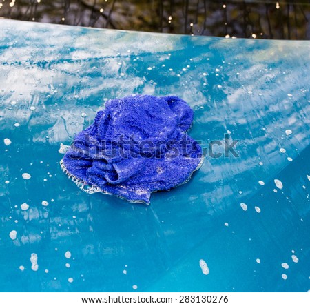Blue car wash cloths on the hood of a blue car.