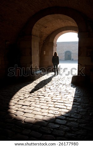 Historic arch with back lit woman standing
