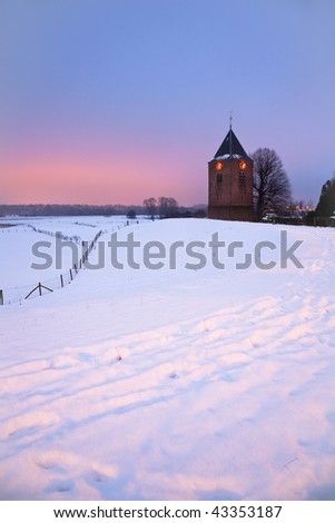 Medieval church in snow and sunset/sunrise sky