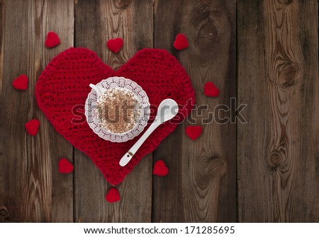 Cup of coffee with whipped cream on a red knitted heart. Card to the Valentine\'s Day