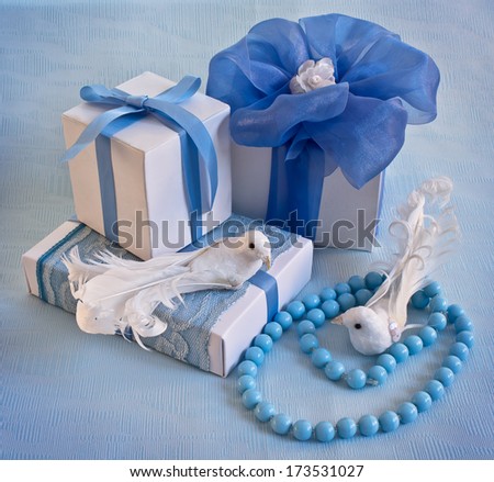 White gift boxes with blue ribbons and two birds