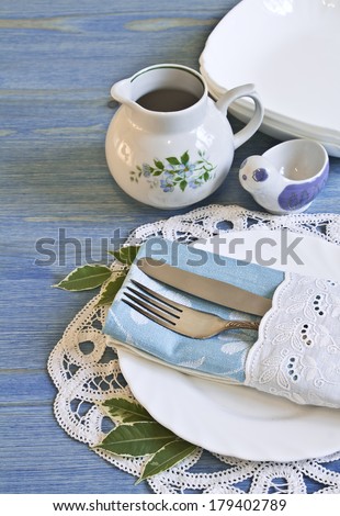 Vintage table setting with leaves decorations, napkins on a blue wooden board background
