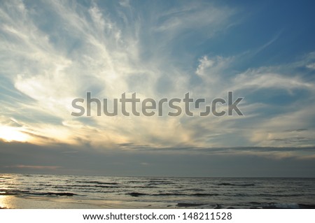 Cirrus clouds in the evening sky over the sea. Sunset
