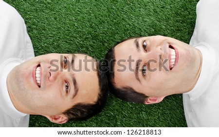 Two attractive positive smiling young men twins
