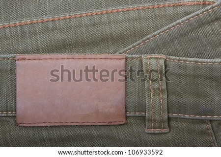 Blank leather jeans label sewed on a  green jeans