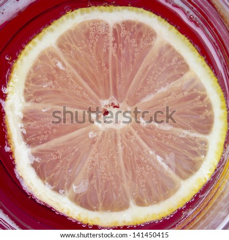 Single cross section of lemon in the glass of drink