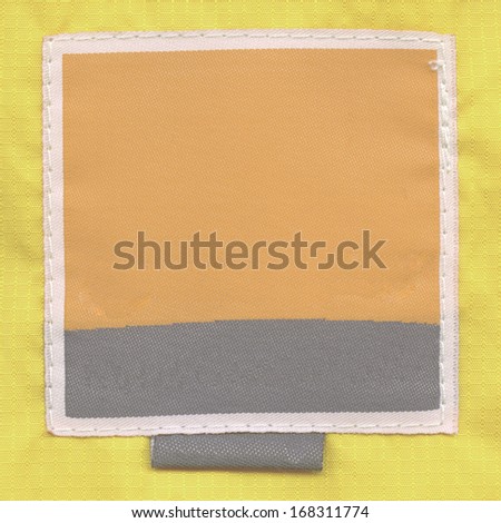 yellow-black textile label  on yellow fabric background
