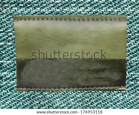Blank bicolor leather jeans label on fabric background