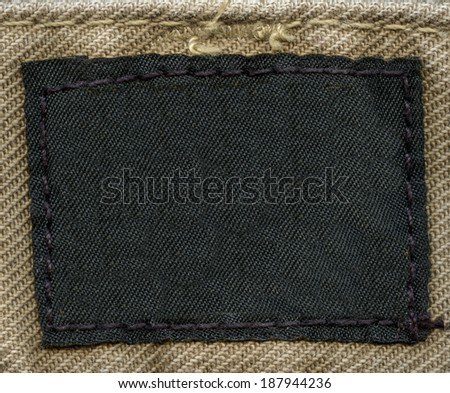 blank black fabric label on textile background.