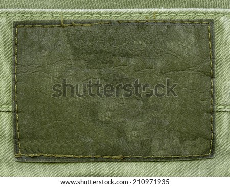 blank old  green  leather label on fabric background