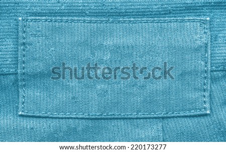 blank blue fabric label on  blue textile background