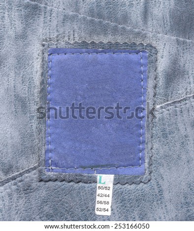 blue blank textile tag on artificial leather background