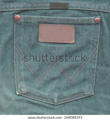 green jeans back pocket with label on jeans background