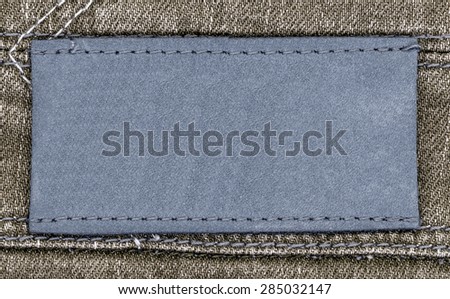 blue blank leather label on brown jeans background