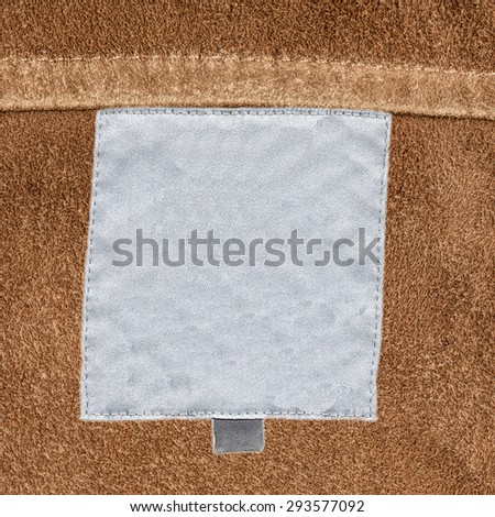 white textile label on background of natural leather