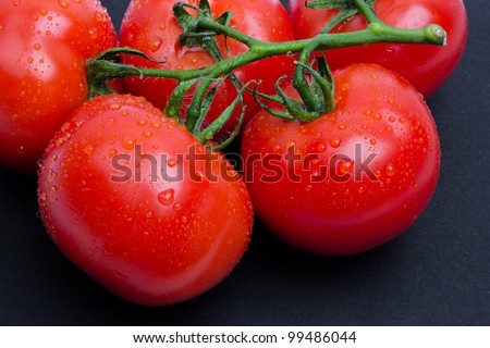 Wet tomatoes isolated on black, tomatoes covered drops